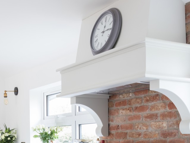aga mantle shelf painted white with sculptural support arms and clock resting on top