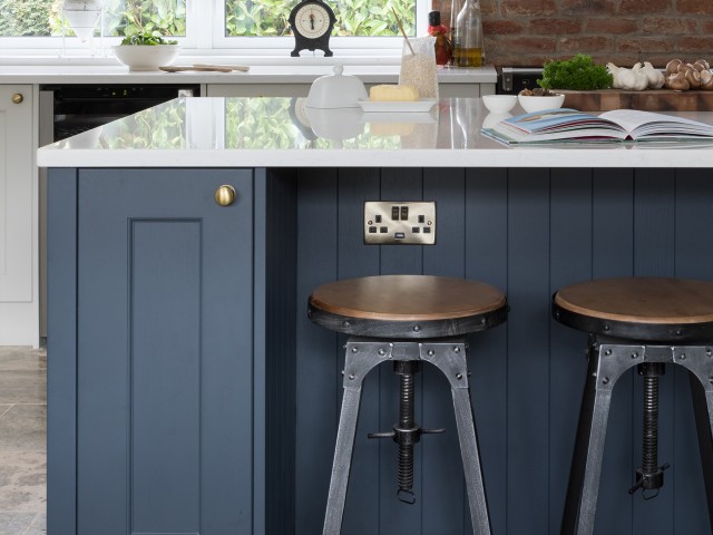 kitchen island with blue shaker-style cabinets, power-point and industrial style stools