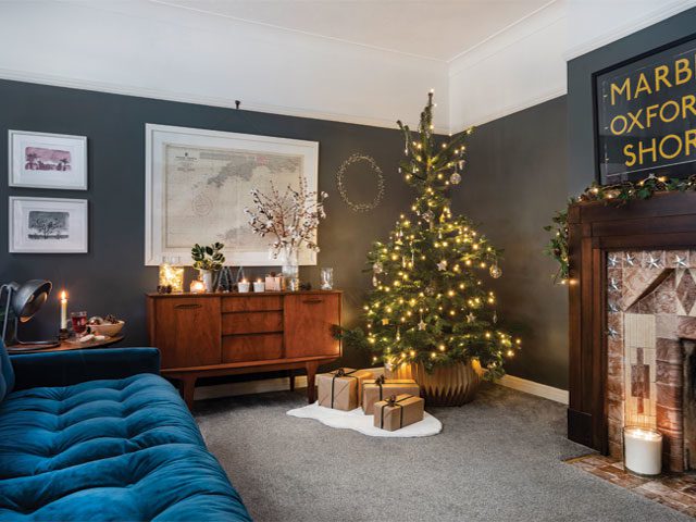 living room with grey walls, period cornicing and fireplace, teal-blue sofa and christmas tree