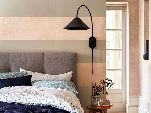 Paint a bold horizontal stripe on the wall and add a statement lamp for impact. 