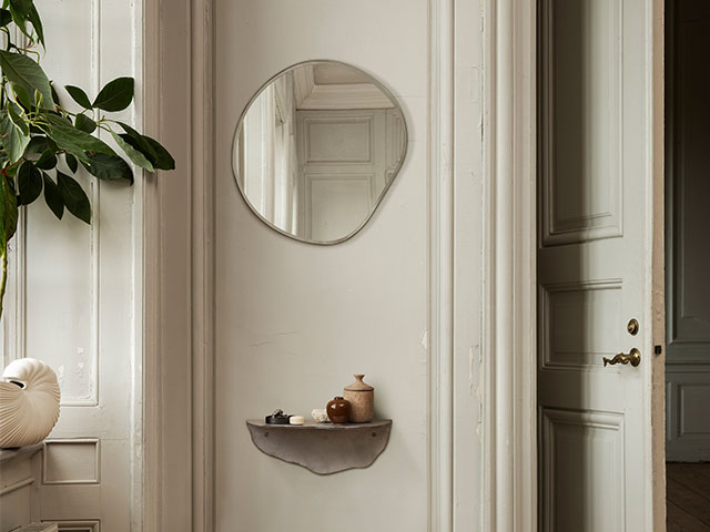 puddle mirror on a bedroom wall with aged white walls and puddle shelf below