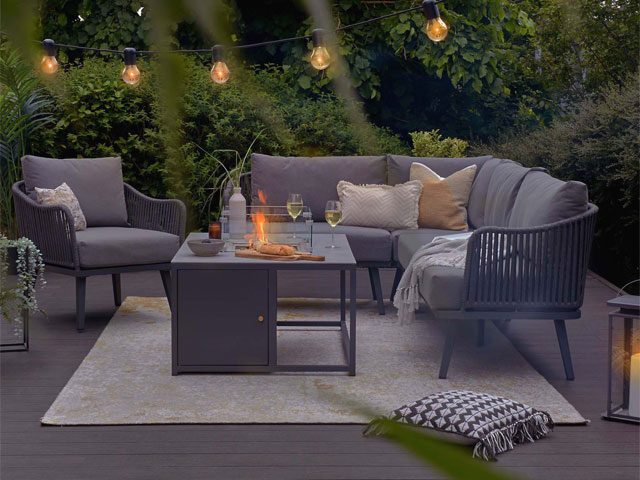 firepit garden table with cushions and blankets and festoon lights