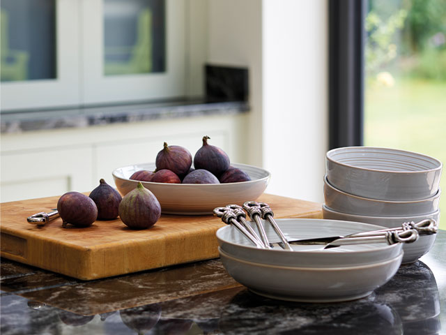 Dark work surfaces add a moody edge to this kitchen extension