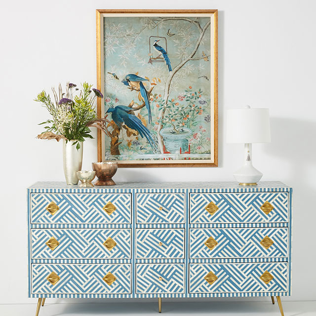 Patterned sideboard decorated with floral vase, white lamp and ornaments