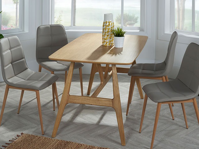Wooden dining table on laminate flooring in bay window