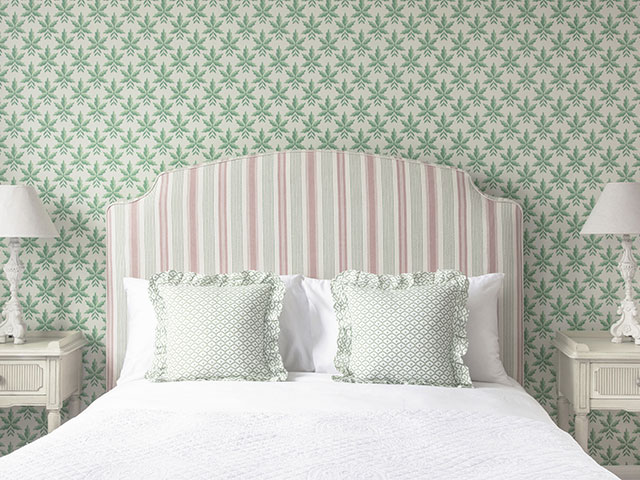 Contrast a striped headboard and patterned wallpaper