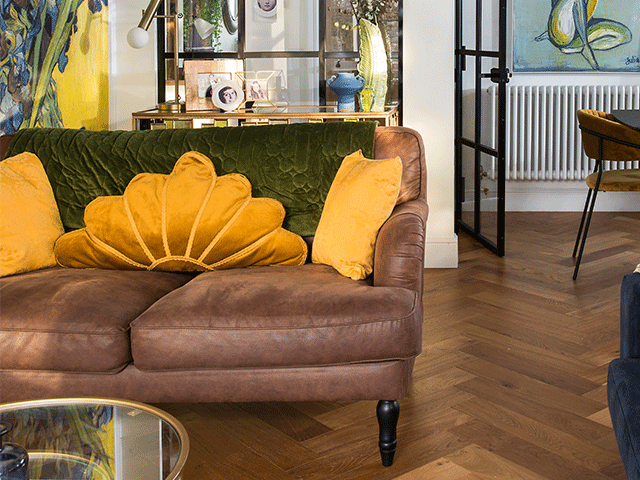 A brown leather sofa with bright yellow cushions