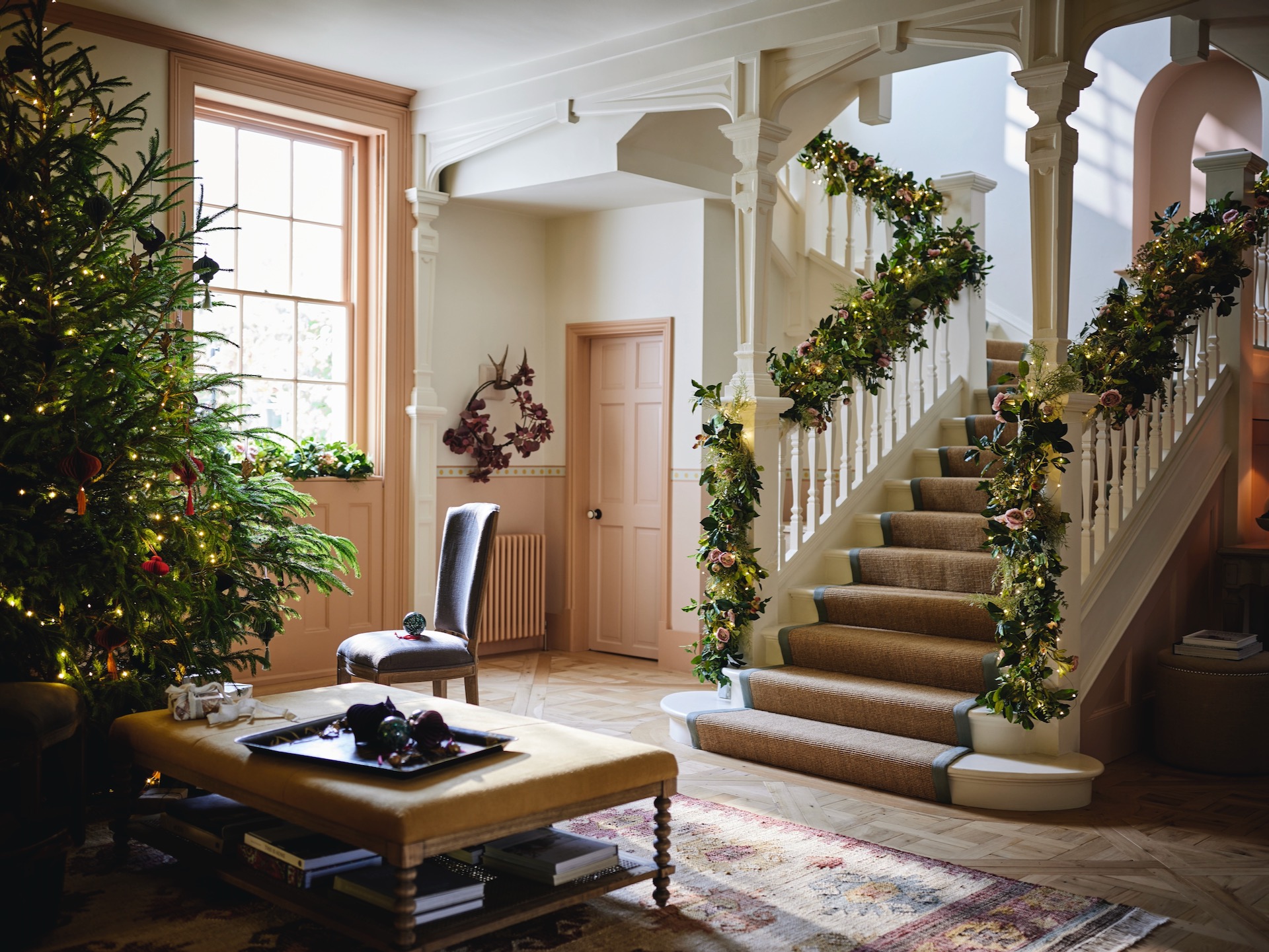 Large open-plan Christmas hallway with tree, and wide staircase