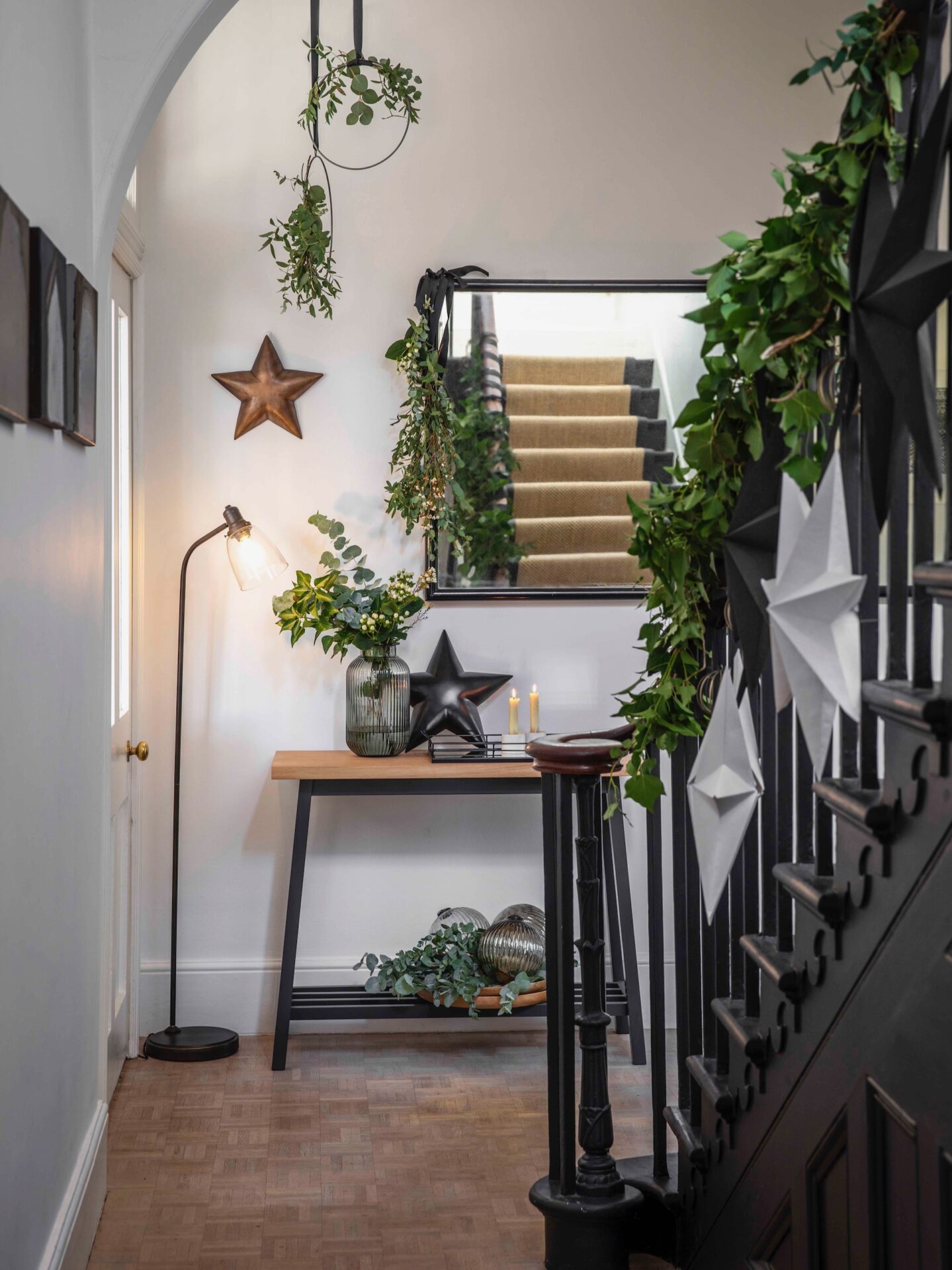 Monochrome hallway dressed in foliage for Christmas