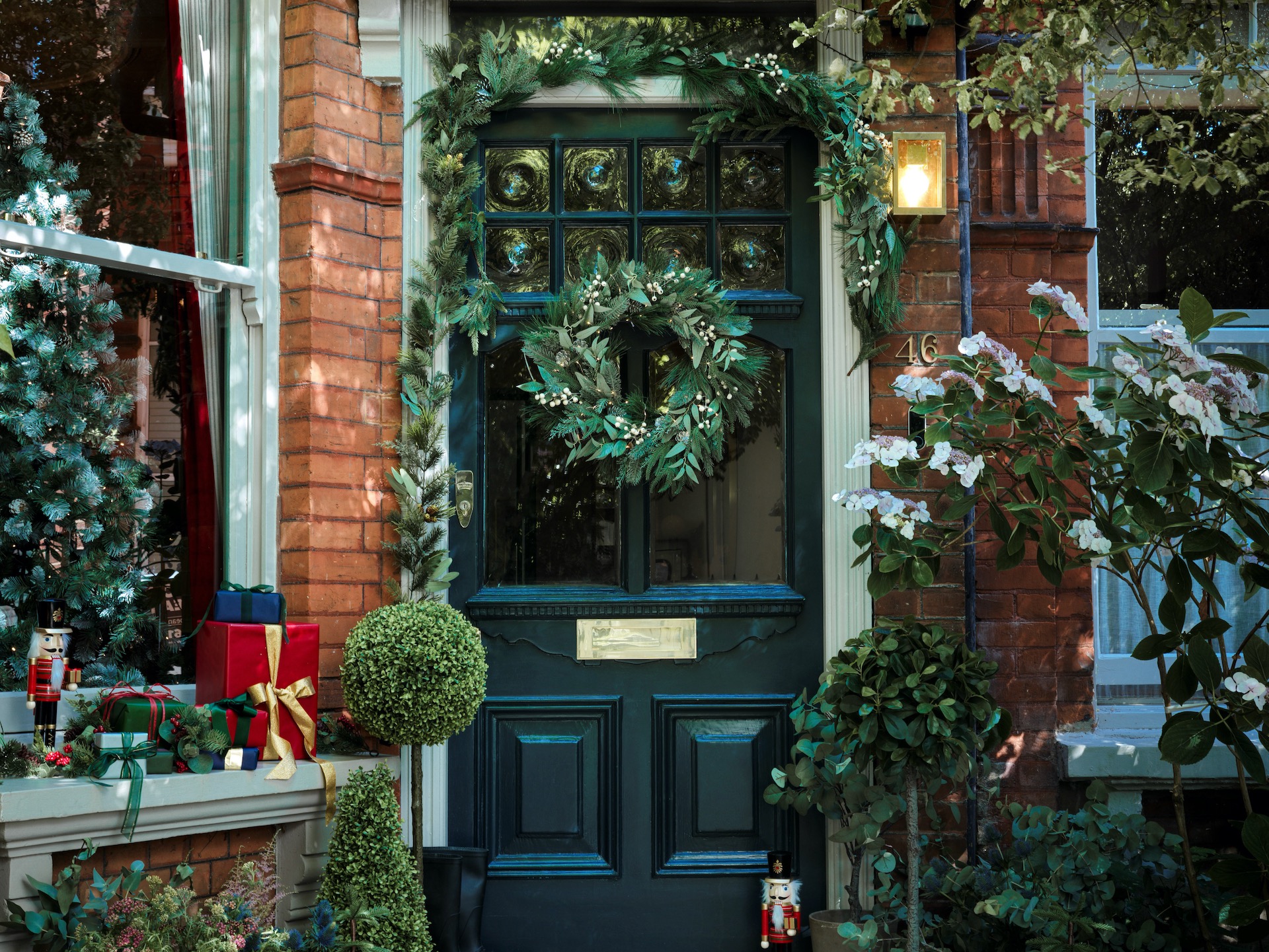 Green front door with foliage wreath and garland by Habitat