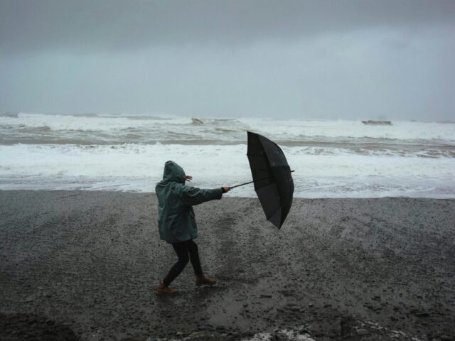 Woman holding umbrella during storm heavy winds