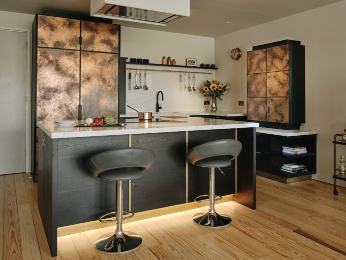 Black kitchen cabinets with patinated copper doors by Ledbury Studio