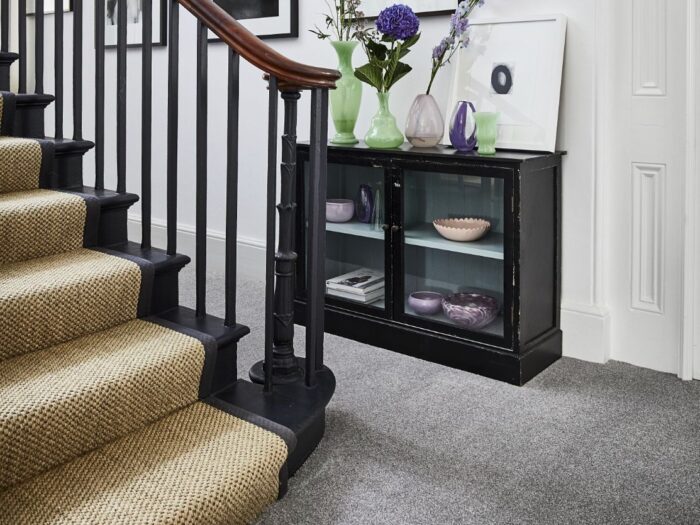 Hallway with grey carpet and ochre stair runner