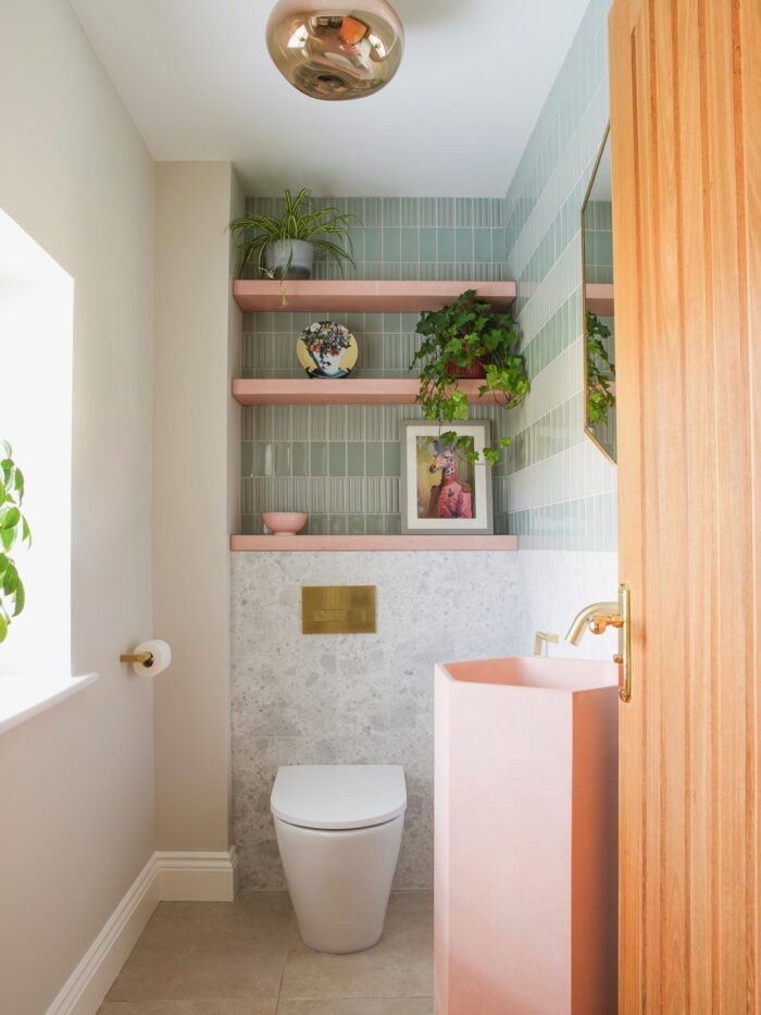 Cloakroom with toilet, pink basin and shelves and green tiles