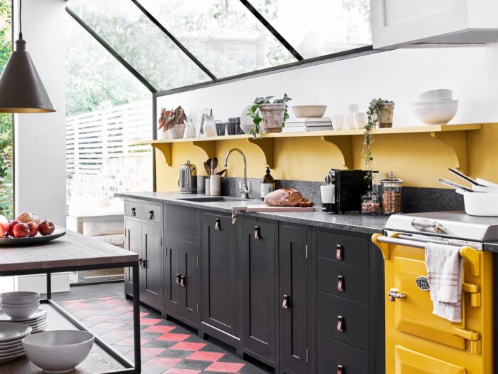Galley kitchen with black cabinets and yellow mini range