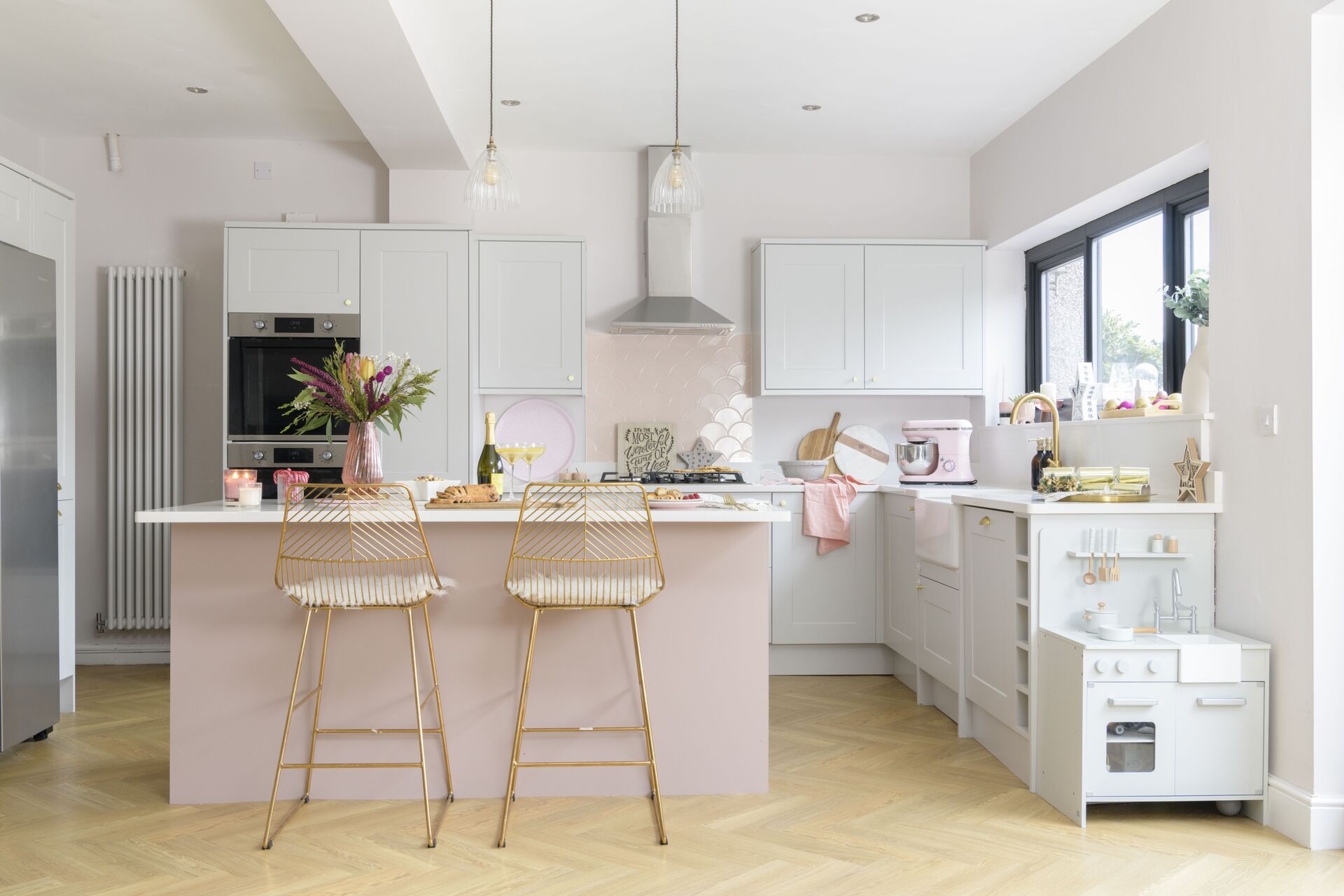 Modern pink and white kitchen with island and breakfast bar