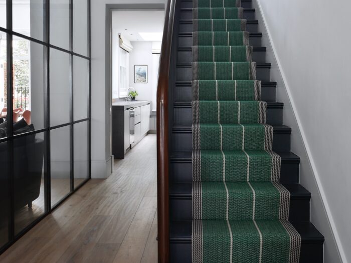 Green stair runner in hallway with Crittall-style room divider