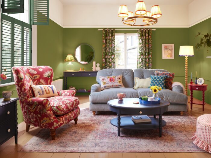 Green living room with blue sofa and pink armchair