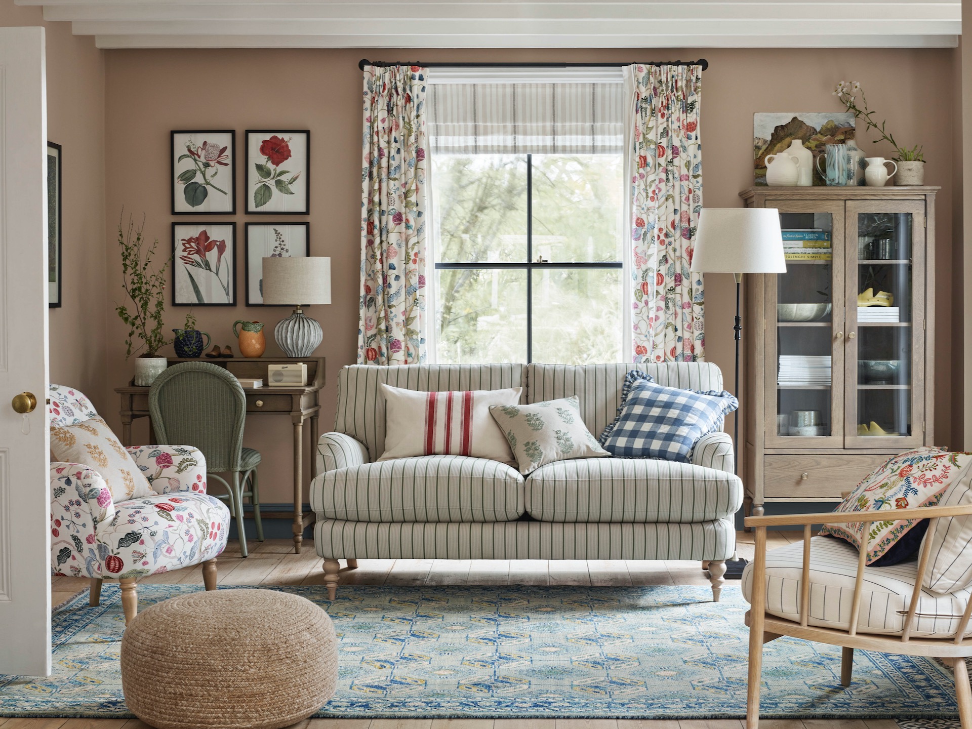 Country living room with floral curtains and striped sofa