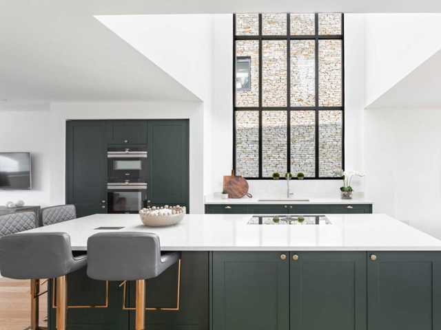 (A perfect kitchen with dark green cabinets and a kitchen island)