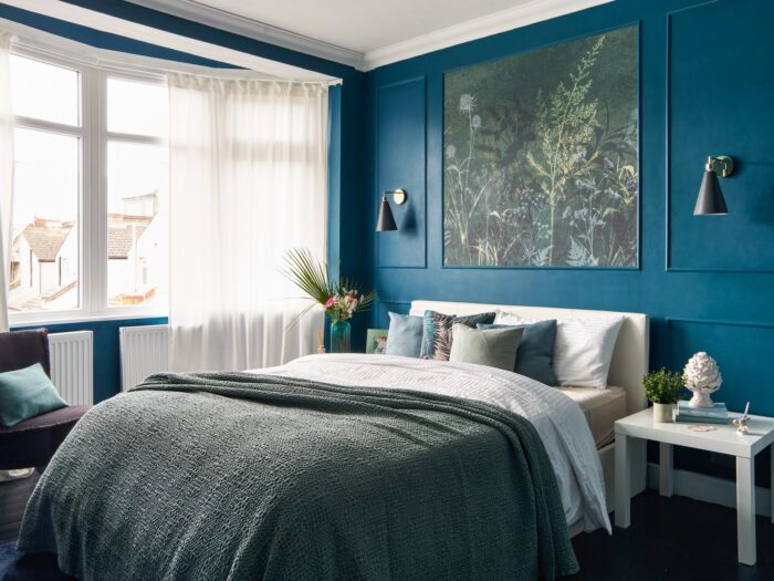 Blue bedroom with grey throw and fauna artwork