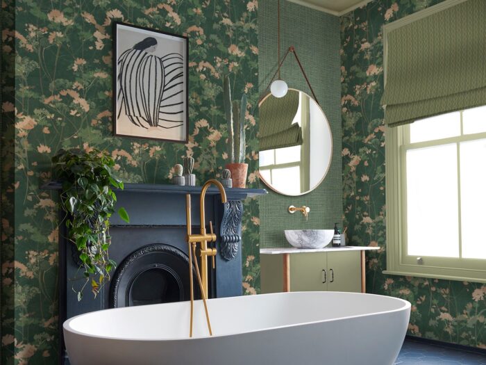 Green bathroom with floral wallpaper, fireplace and freestanding bath
