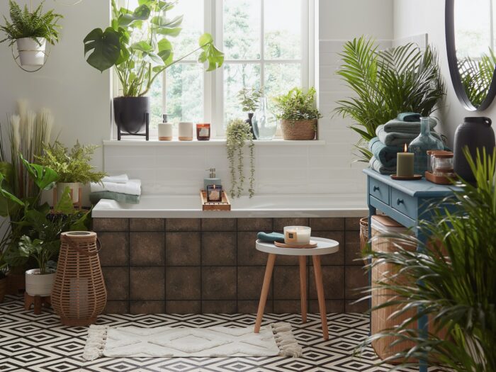 Bathroom with tiles bath panel and lots of plants