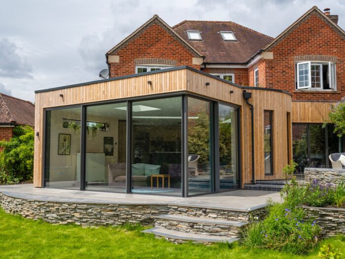 Timber-clad extension with large aluminium framed windows