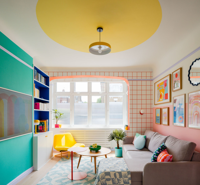 Cosy block colour living room space with prints and plenty of light.