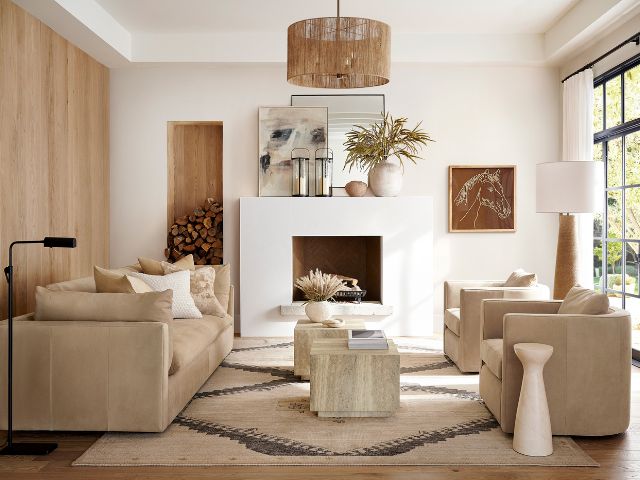 Calming white living room with rug and rattan pendant by Pottery Barn.
