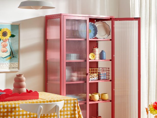 Pink cabinet with curated treasures and checked tablecloth by Mustard