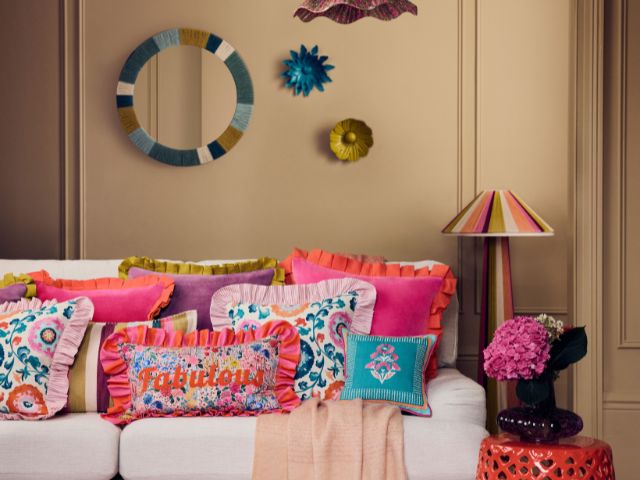 Sofa with brightly coloured and patterned cushions by Sophie Robinson x Dunelm