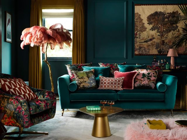 Jewel coloured sofa with cushions in a teal living room by Amanda Holden x DFS