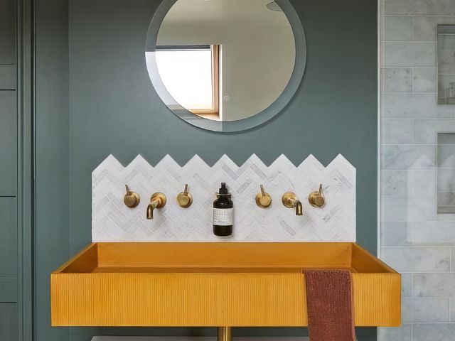 Mustard sink with marble tiles in a bathroom by Hyperion Tiles